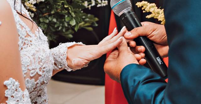 A bride and groom exchange rings during their wedding ceremony.