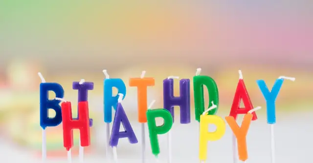 Vibrant birthday candle letters spelling 'Happy Birthday' with a colorful blurred background. Perfect for celebration visuals.