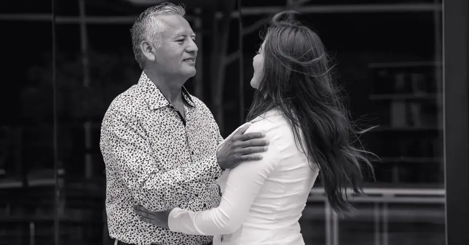 A mature couple embracing warmly while standing face to face in an urban outdoor setting.