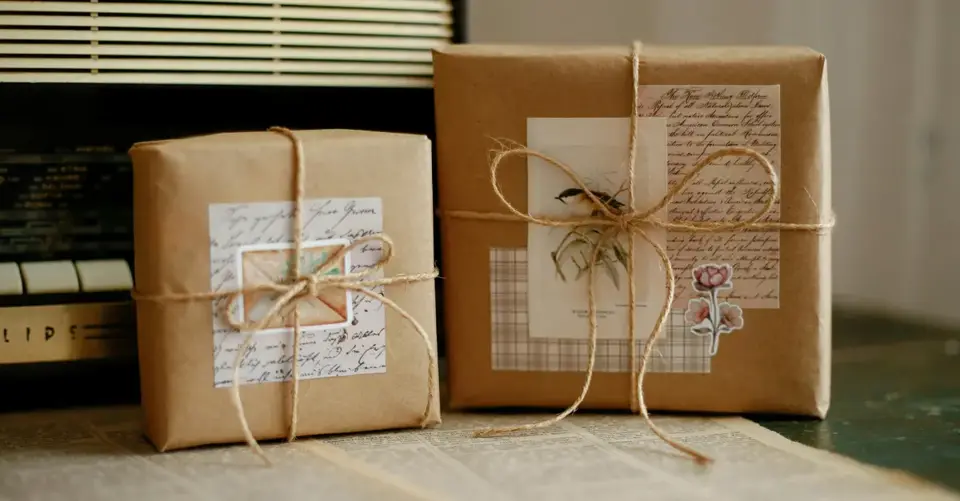 Two vintage gift boxes wrapped in brown paper and twine with retro decoration.