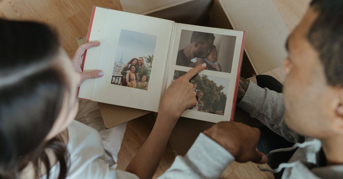 A couple looks through a photo album together in their home.