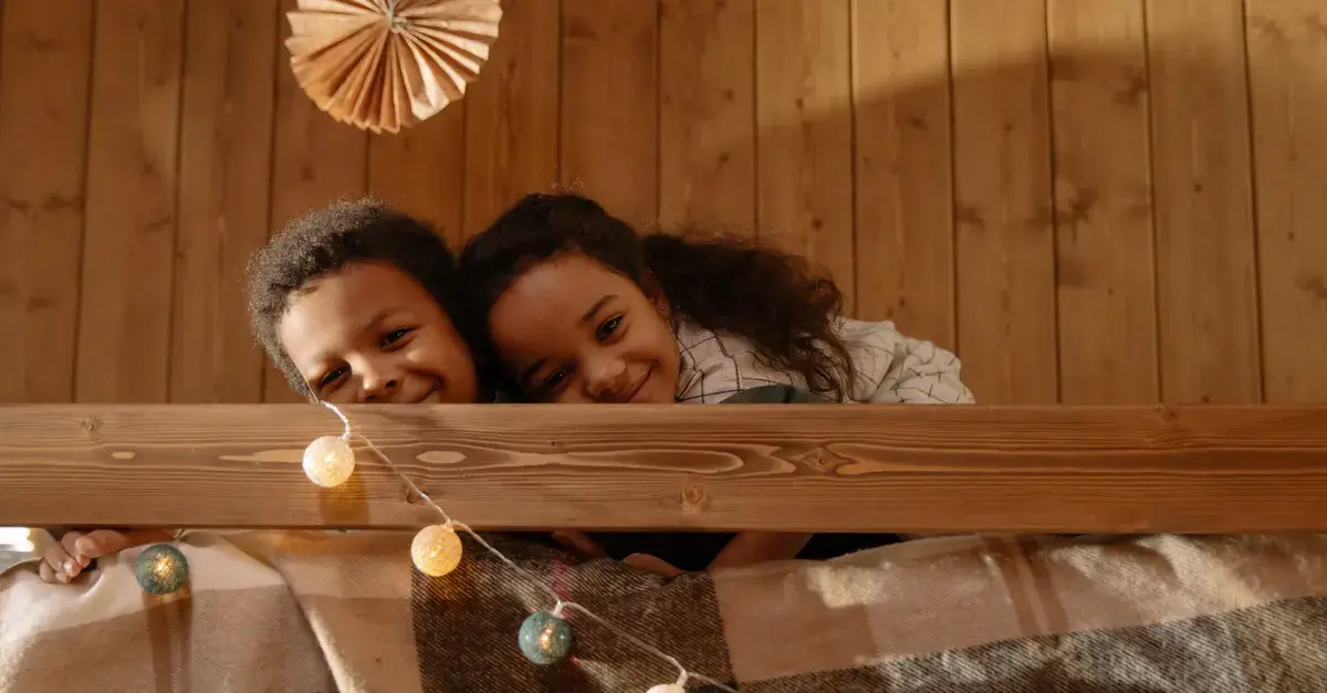Two happy children cuddling on a cozy indoor bed with warm lighting.
