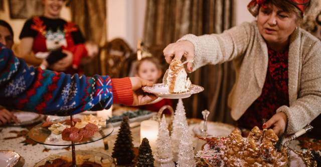 A family shares dessert around a festive holiday table.